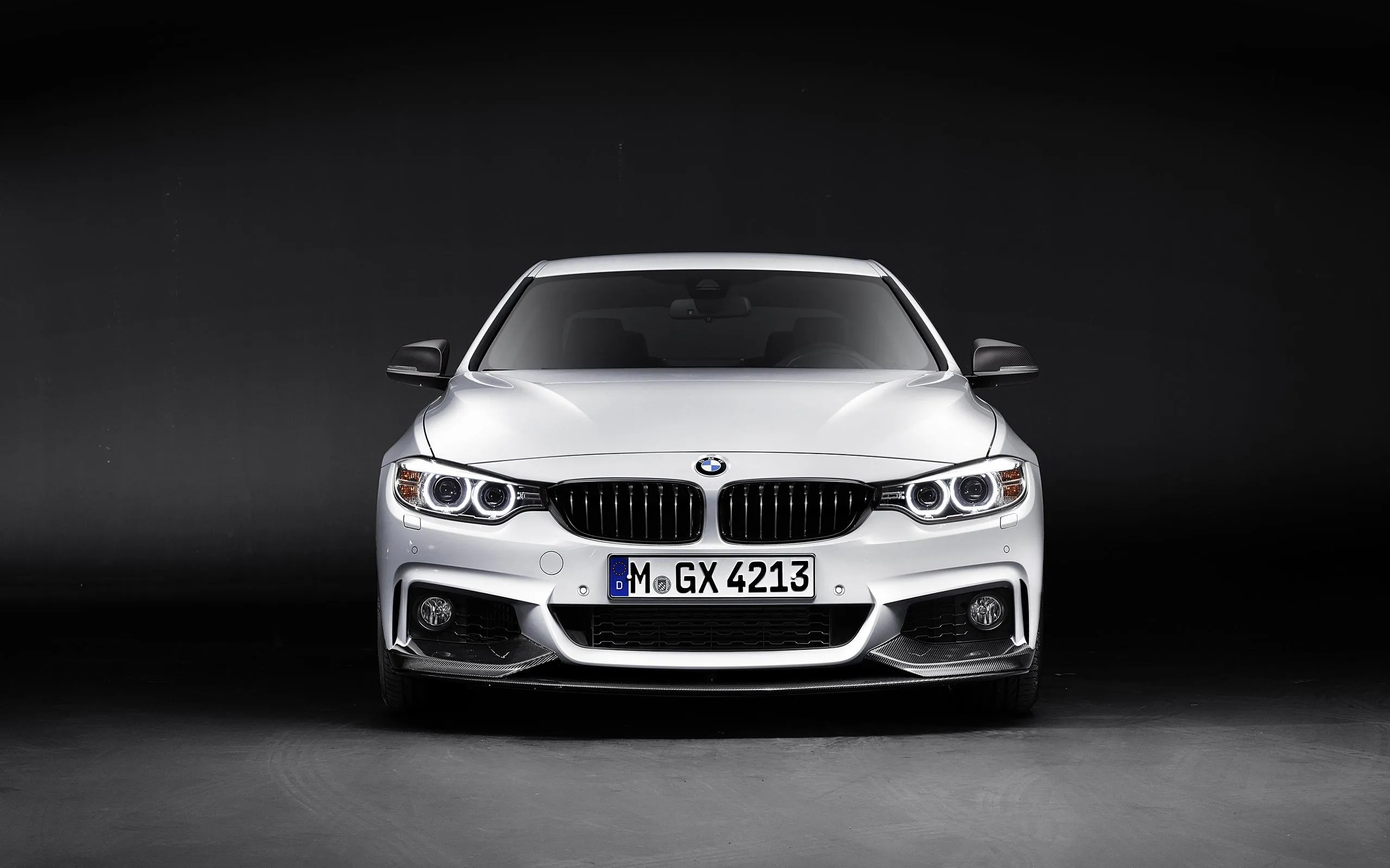 White Bmw Facing Front Against a Dark Studio Background