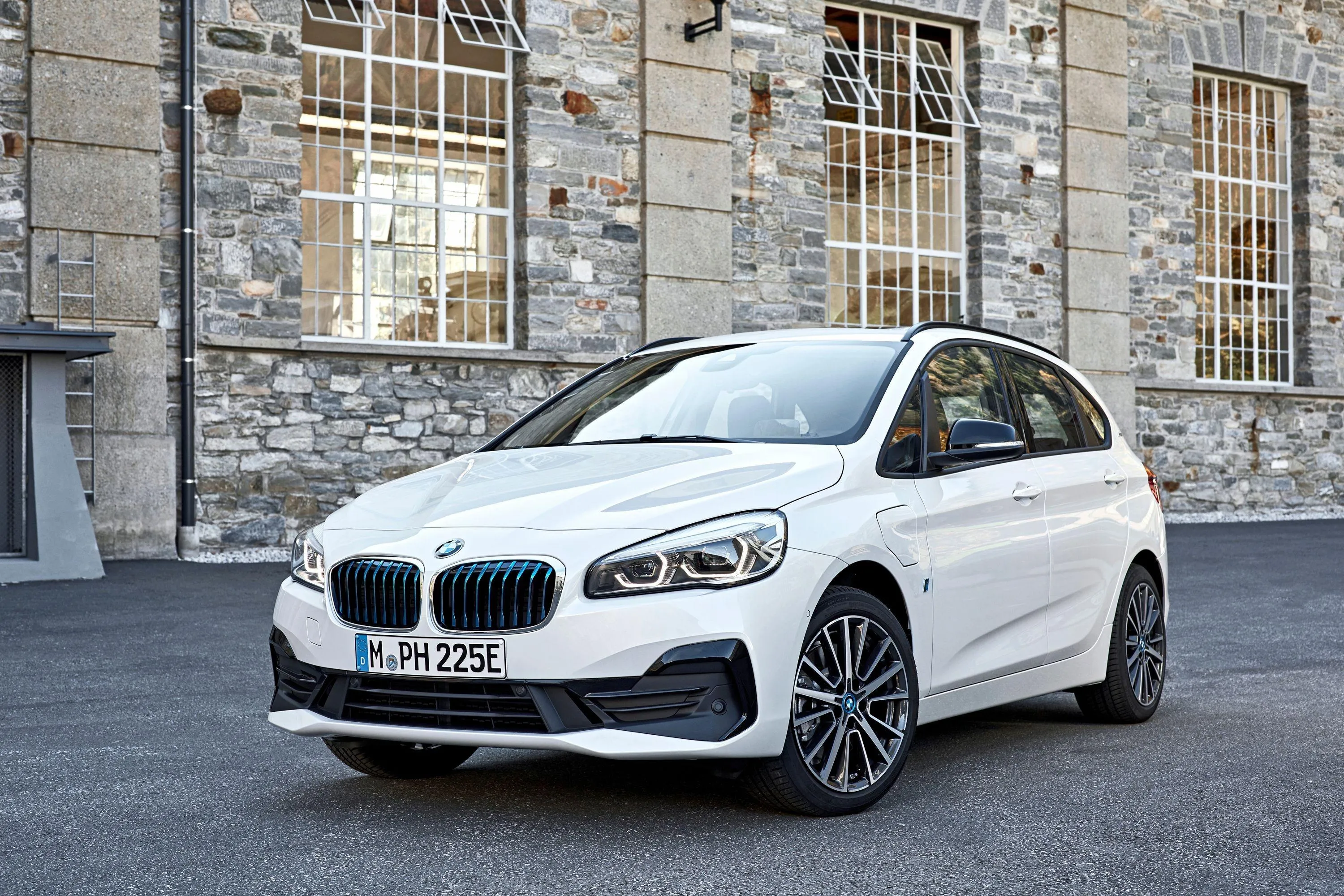 White Bmw Hatchback Parked in Front of Stone Building
