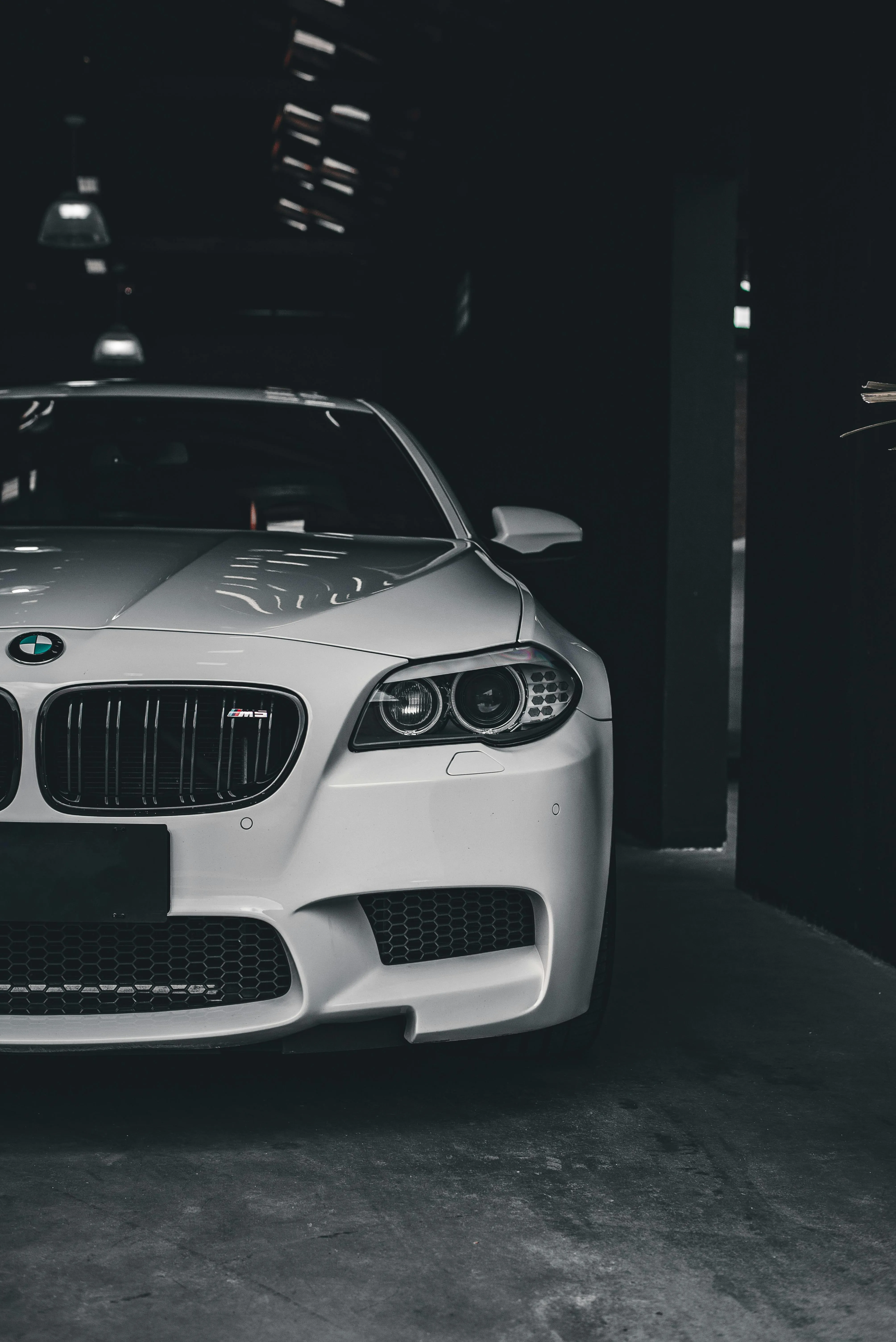 White Bmw Parked in Dim Garage Under Dramatic Lighting