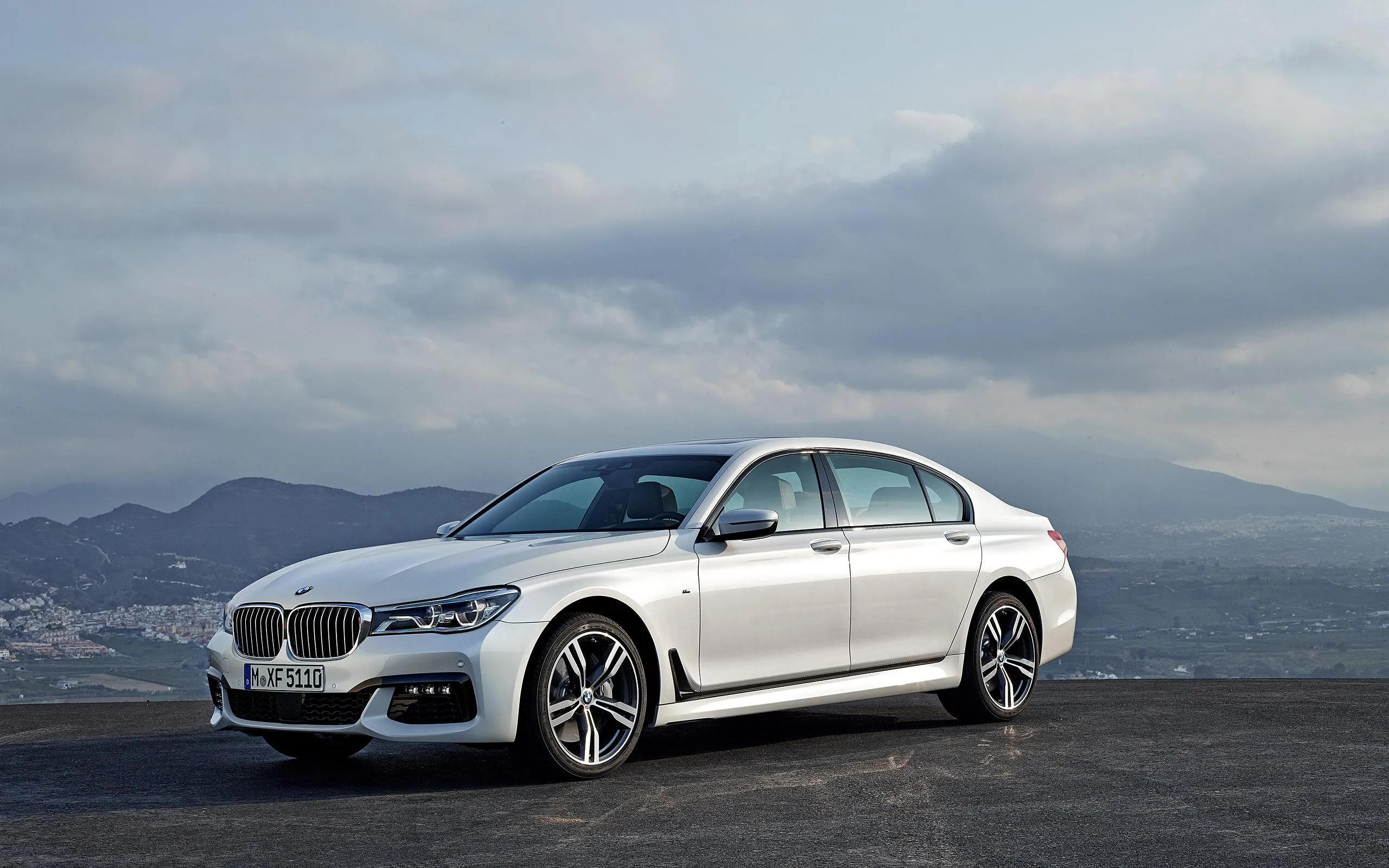 White Bmw Parked Near Open Road Under Cloudy Sky Image