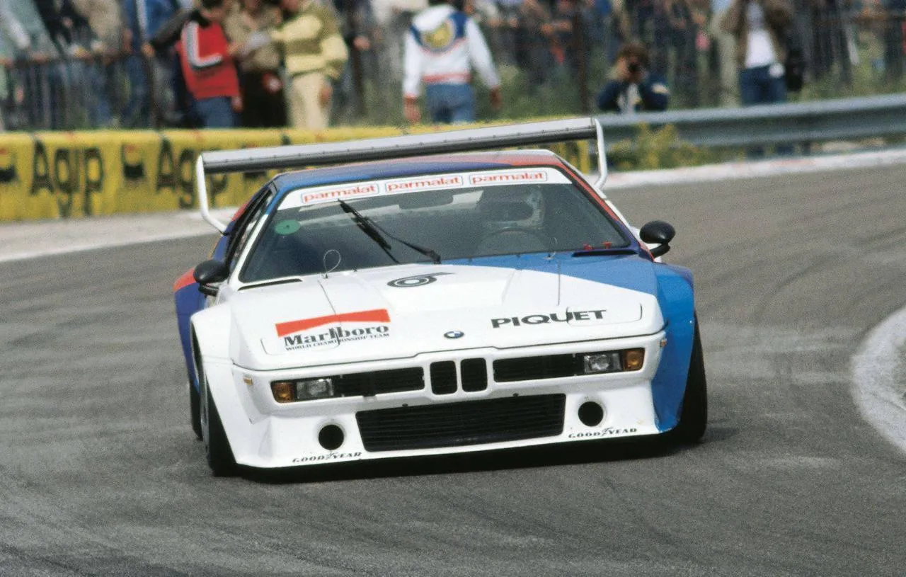 White Bmw Race Car on Track with Crowd in Background