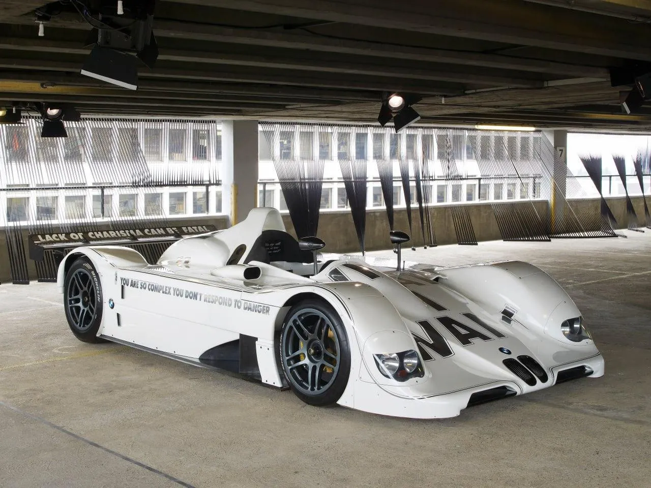 White Bmw Race Car Parked in Covered Garage Area Wallpaper