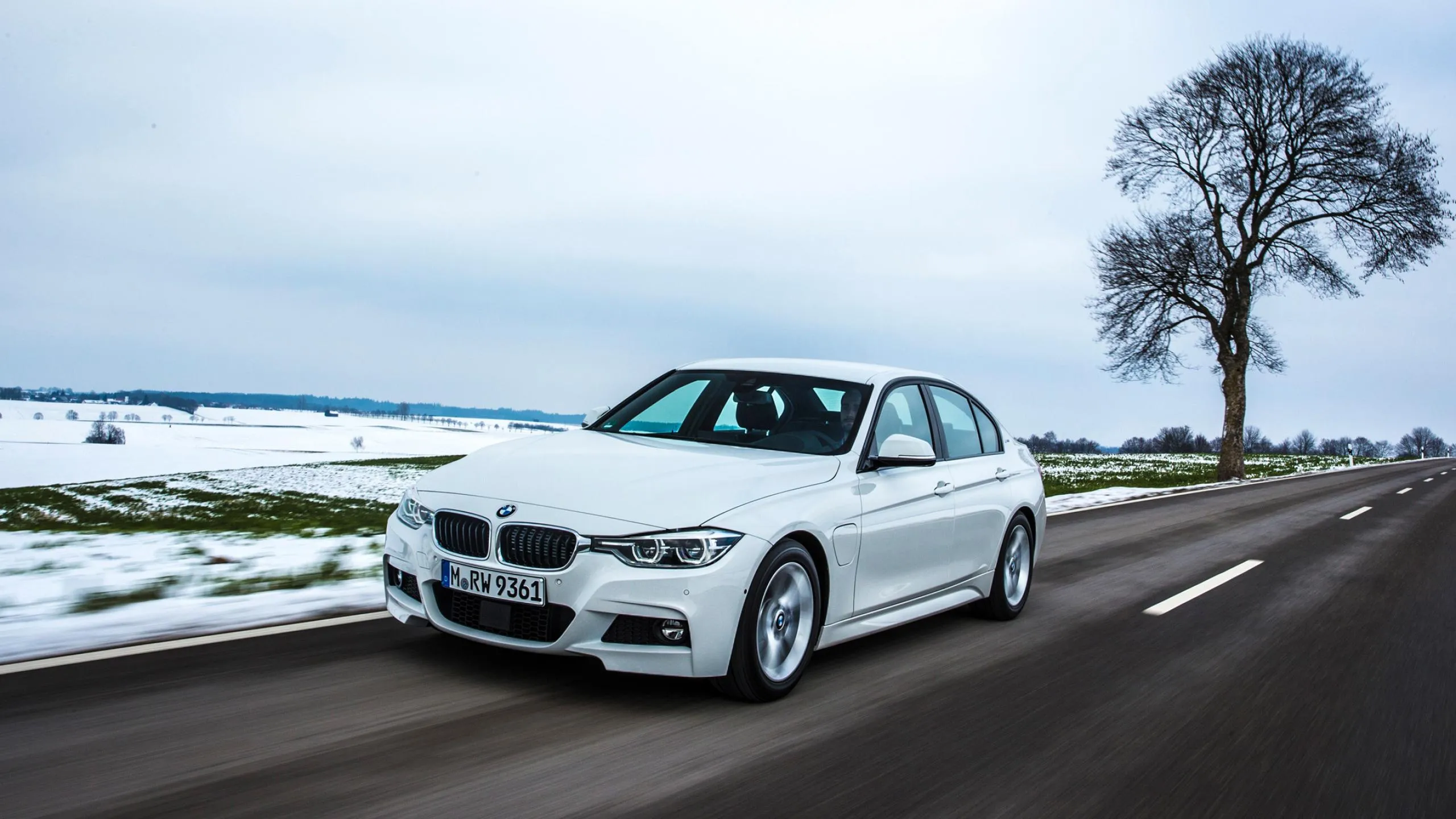 White Bmw Sedan Driving on Snowy Country Road Wallpaper