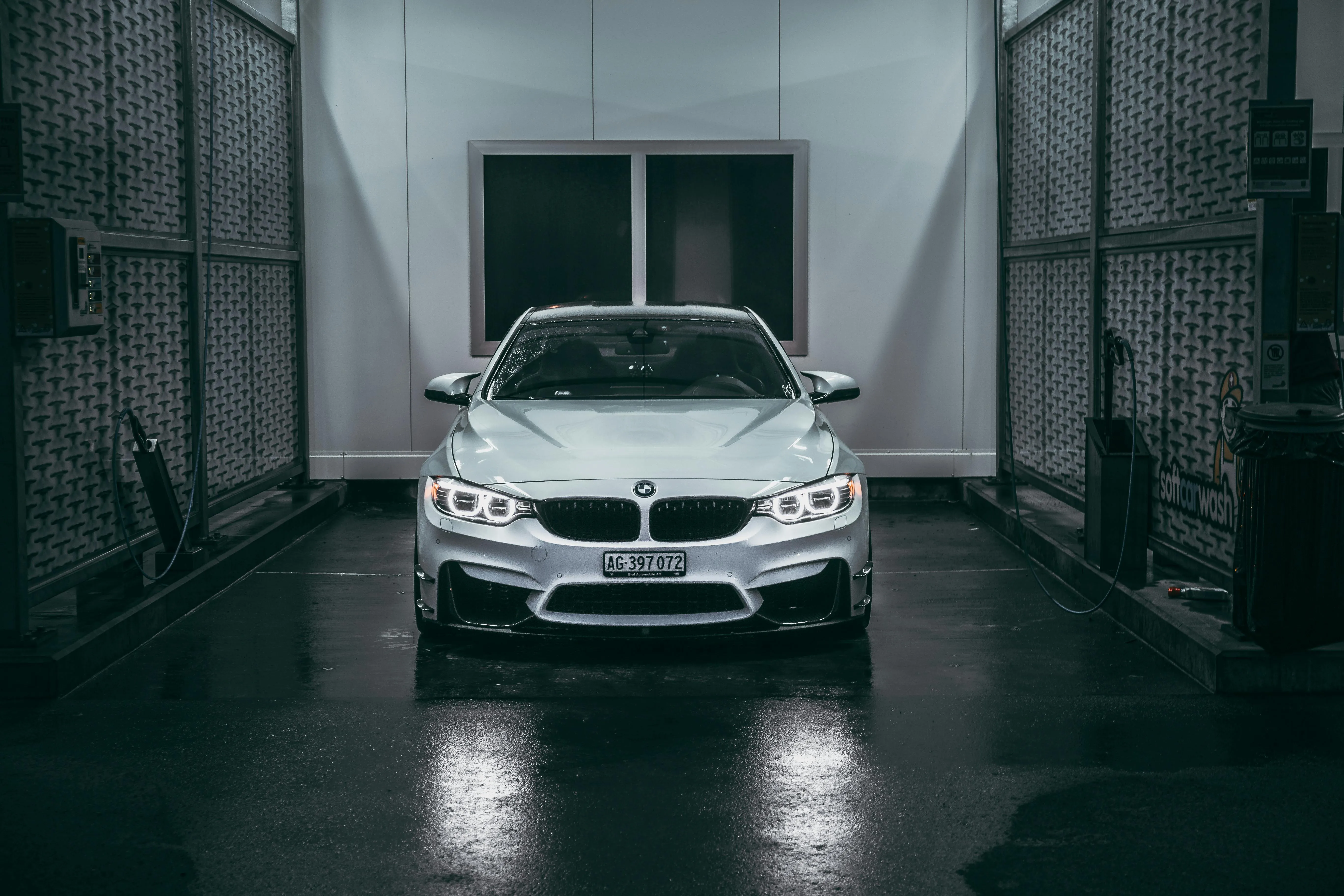 White Bmw Sedan in a Dark Wet Tunnel with Headlights On