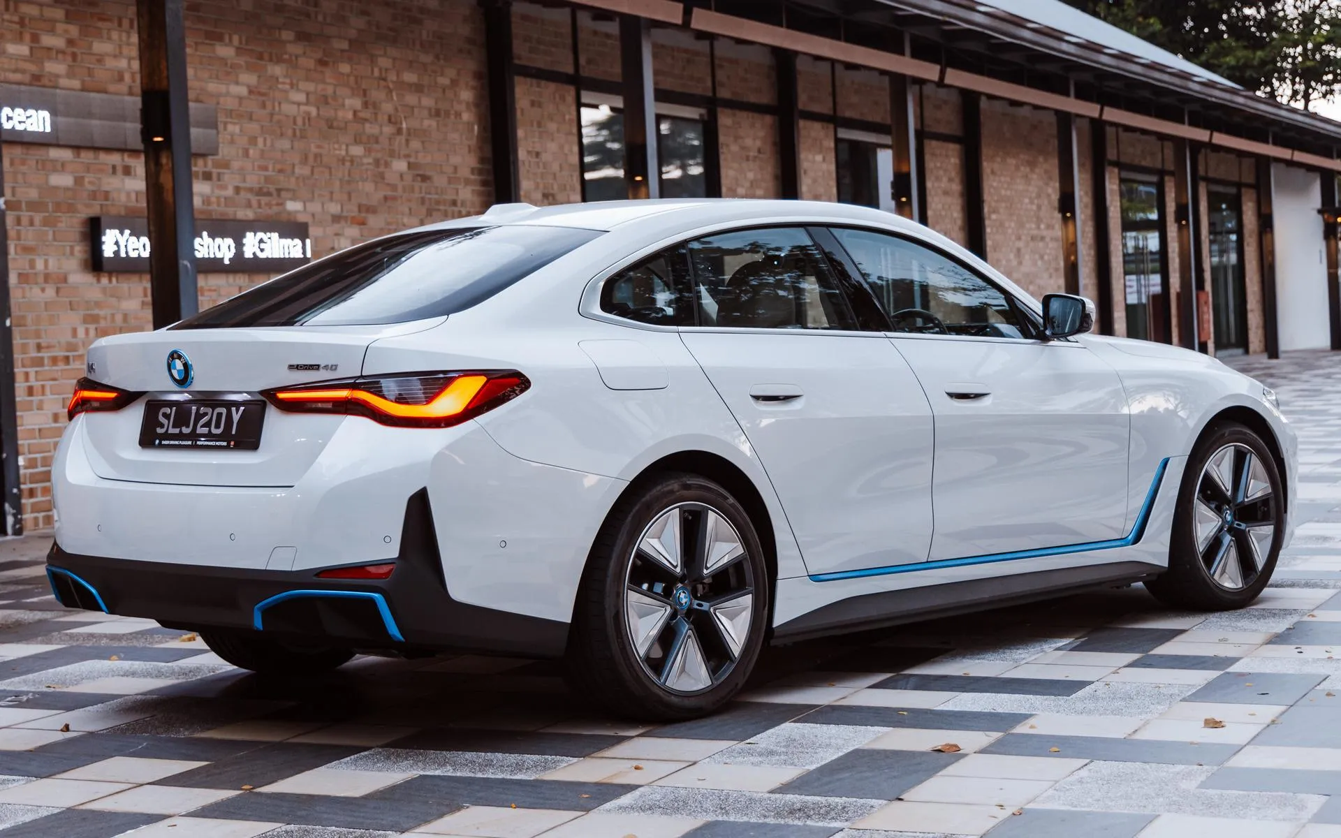 White Bmw Sedan Parked Outside Modern Cafe Building
