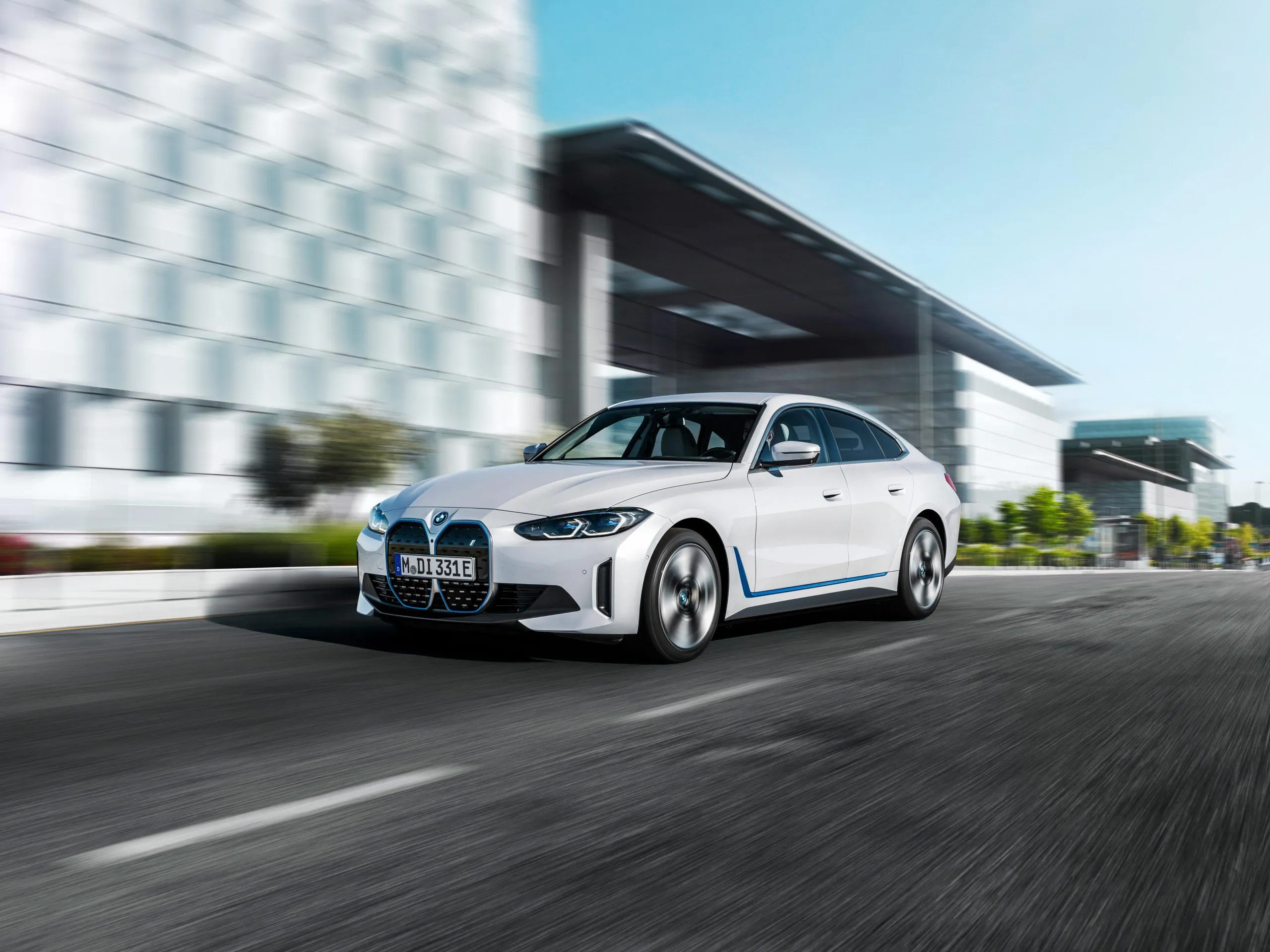 White Bmw Speeding on Urban Street Beside Modern Building
