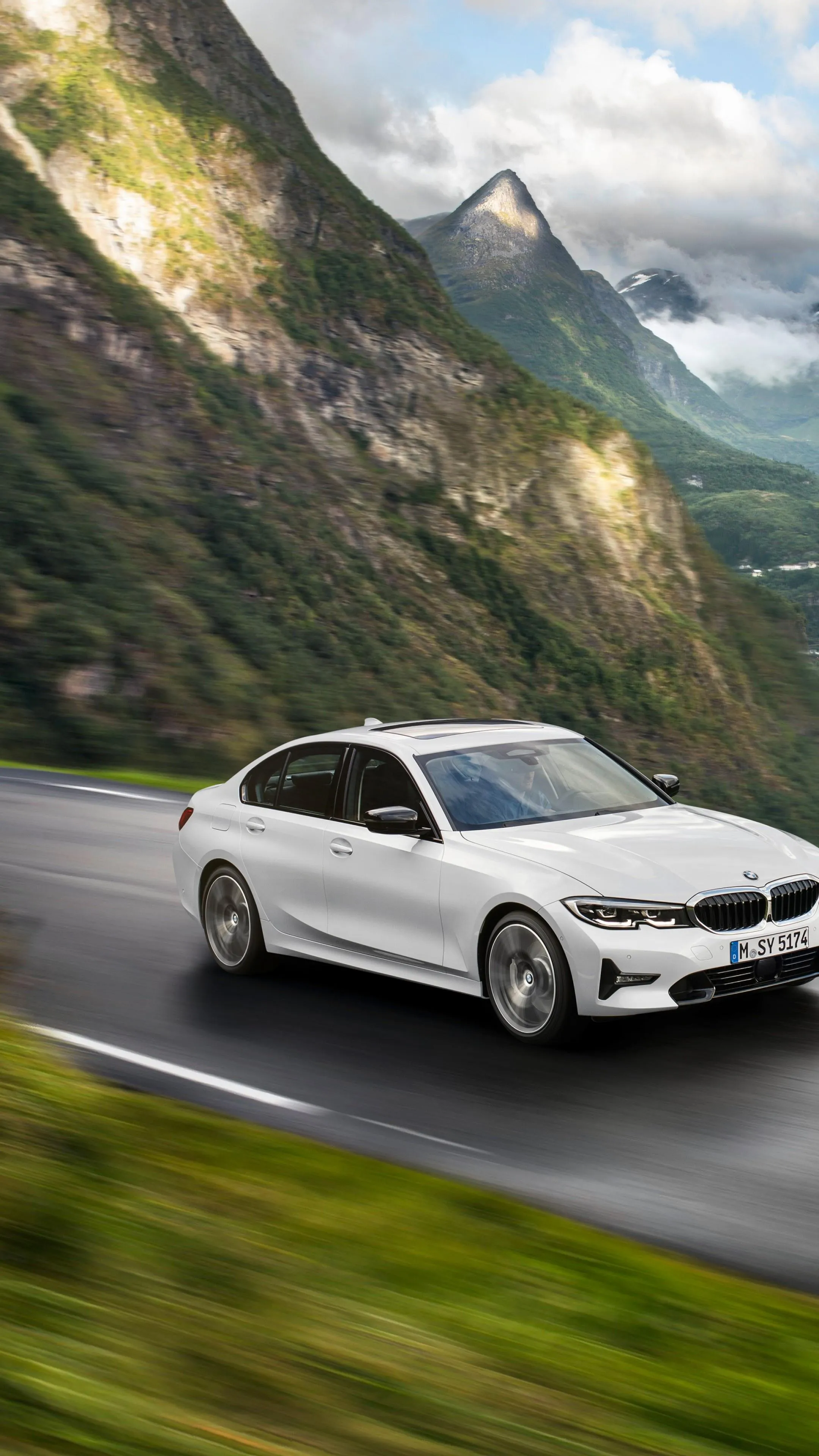 White Bmw Sports Car Driving Through Alpine Road Image