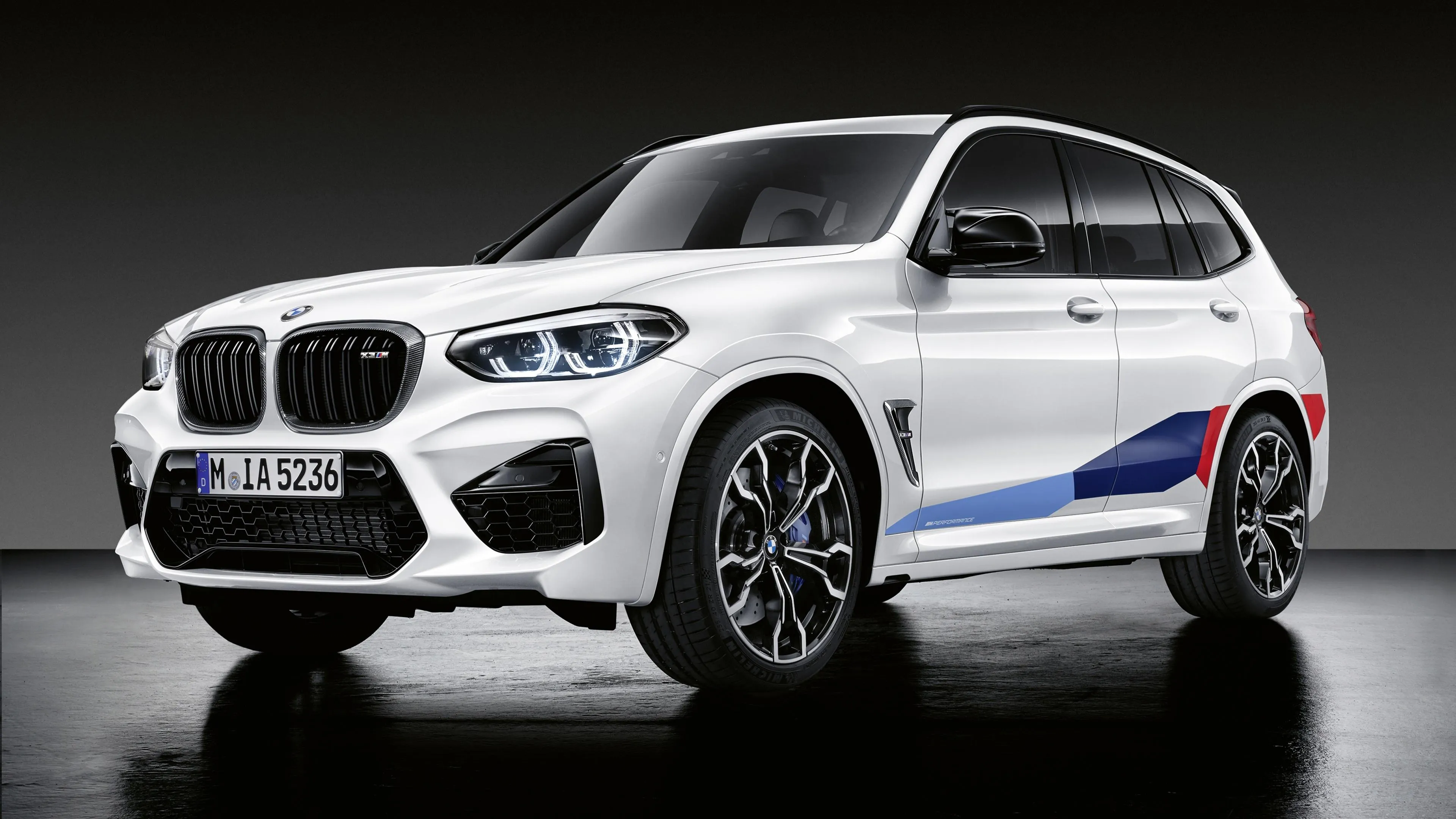White Bmw Sports Suv with Racing Stripes in Studio