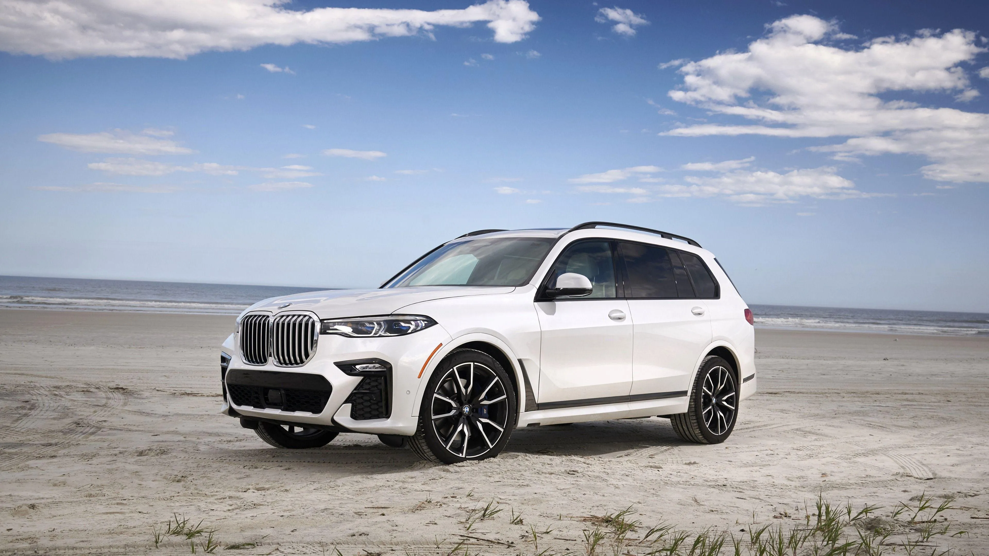 White Bmw Suv Driving on Beachside Road with Blue Sky