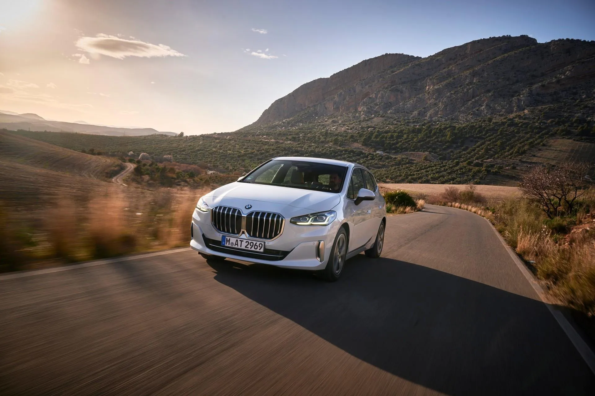 White Bmw Suv on a Winding Road with Sunset in Background