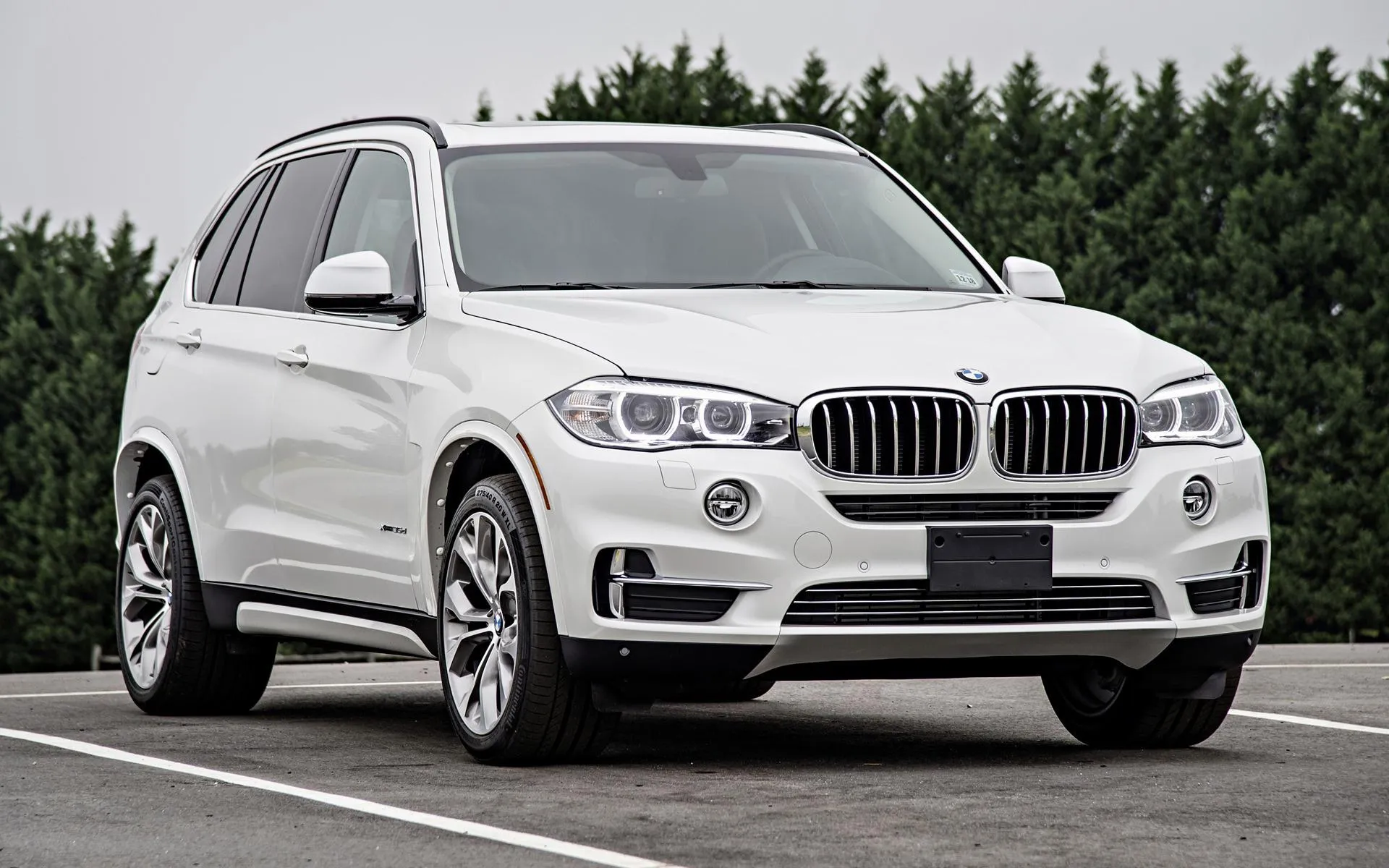 White Bmw Suv Parked Near Trees on a Quiet Street Wallpaper