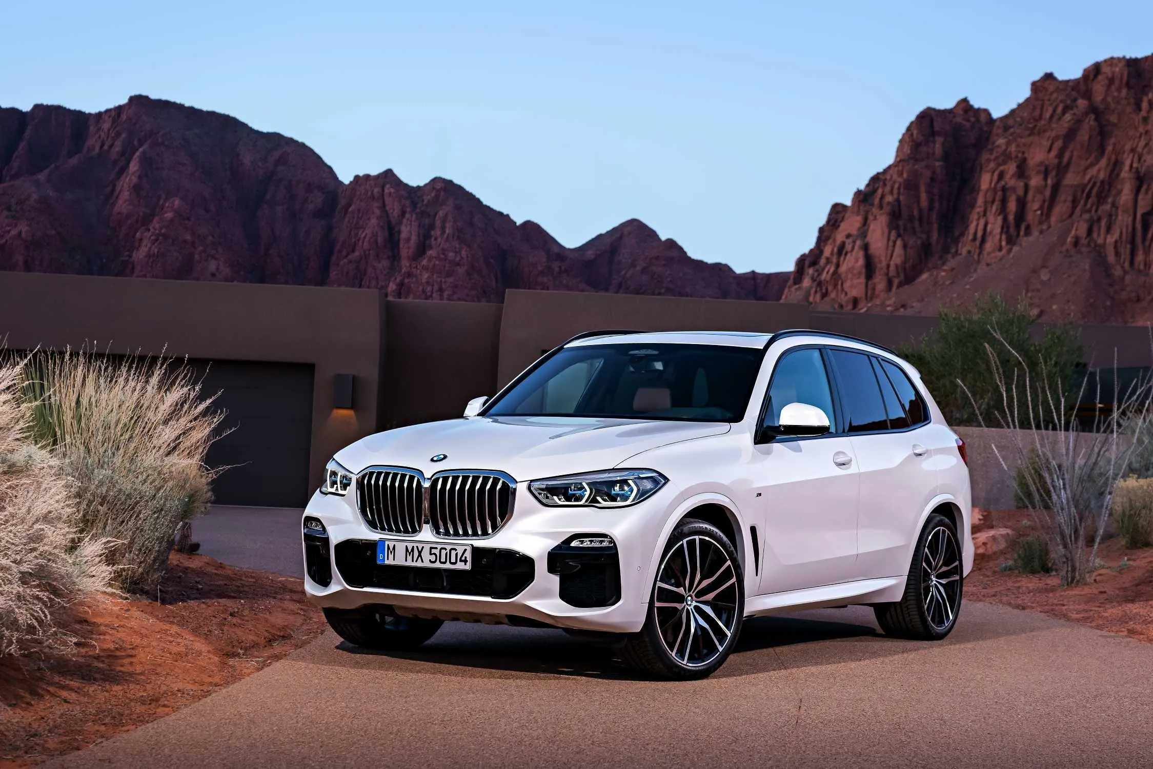 White Bmw Suv Parked on Desert Road Near Red Rocks