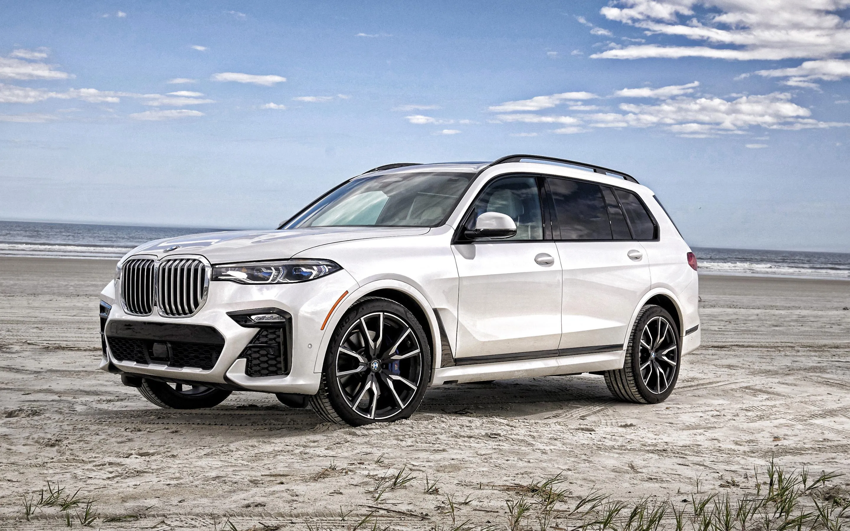 White Bmw Suv Parked on Sandy Beach with Blue Skies