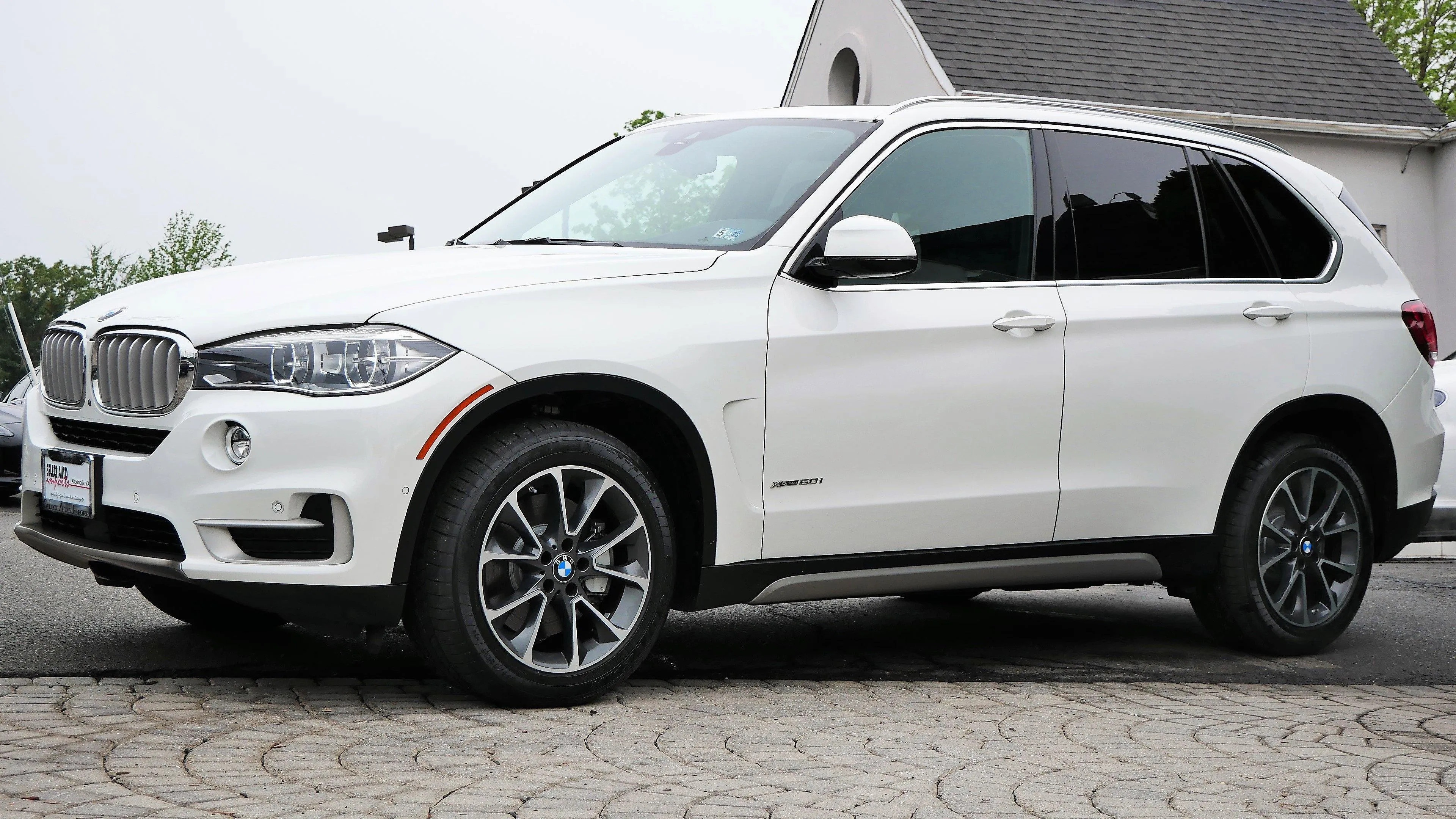 White Bmw Suv Parked Outside a House with Brick Driveway