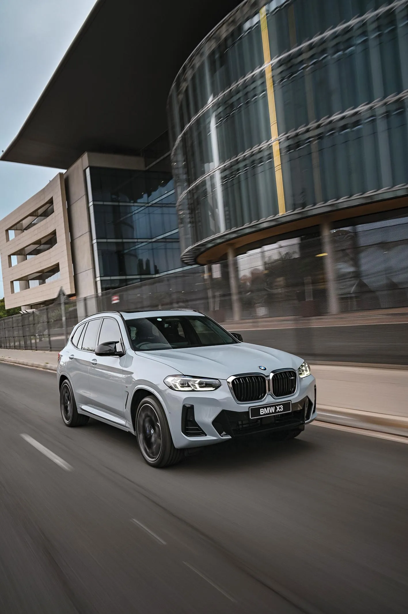 White Bmw Suv Passing Modern Glass Office Building