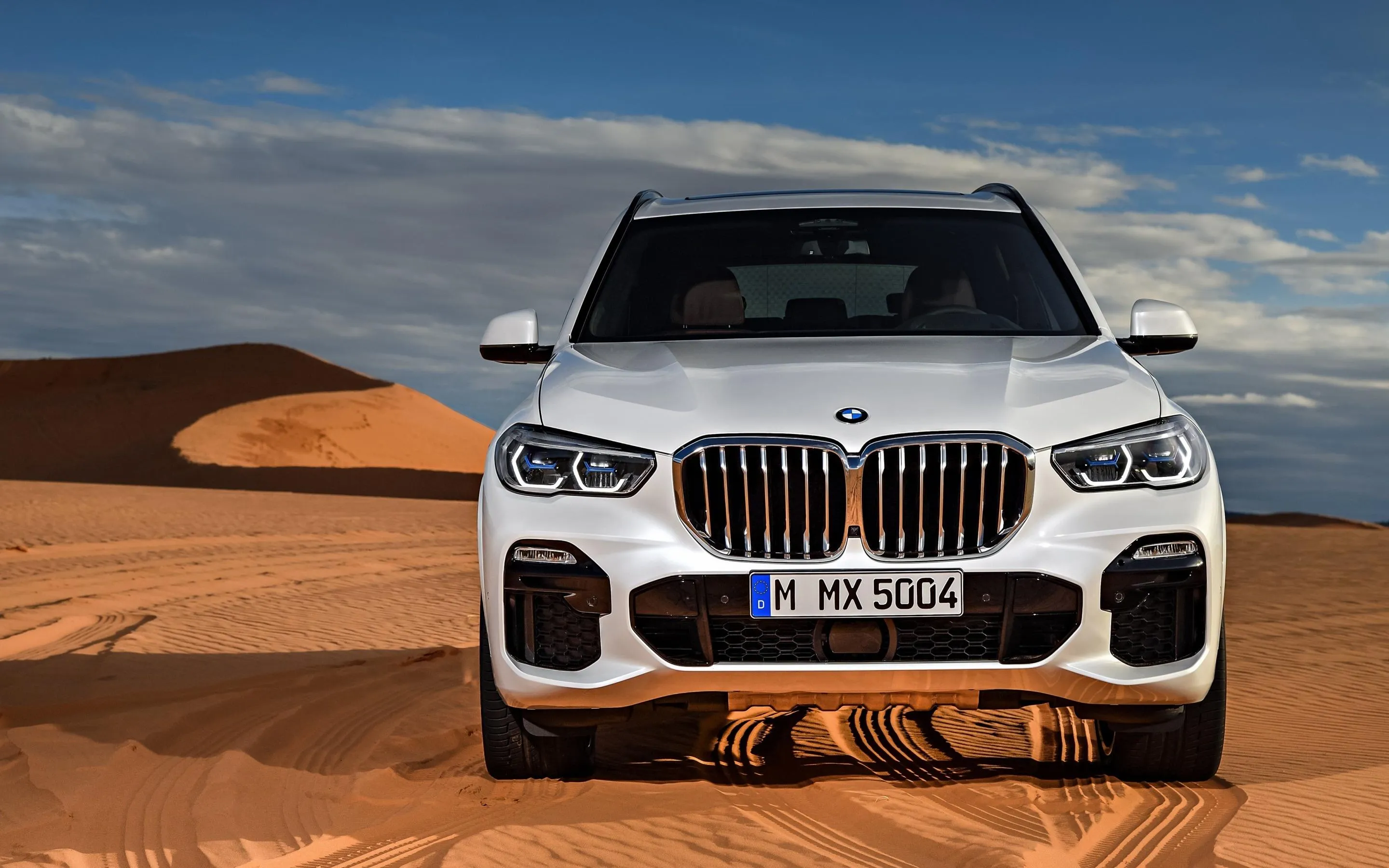 White Bmw Suv Posing on Sandy Desert Roadside Wallpaper