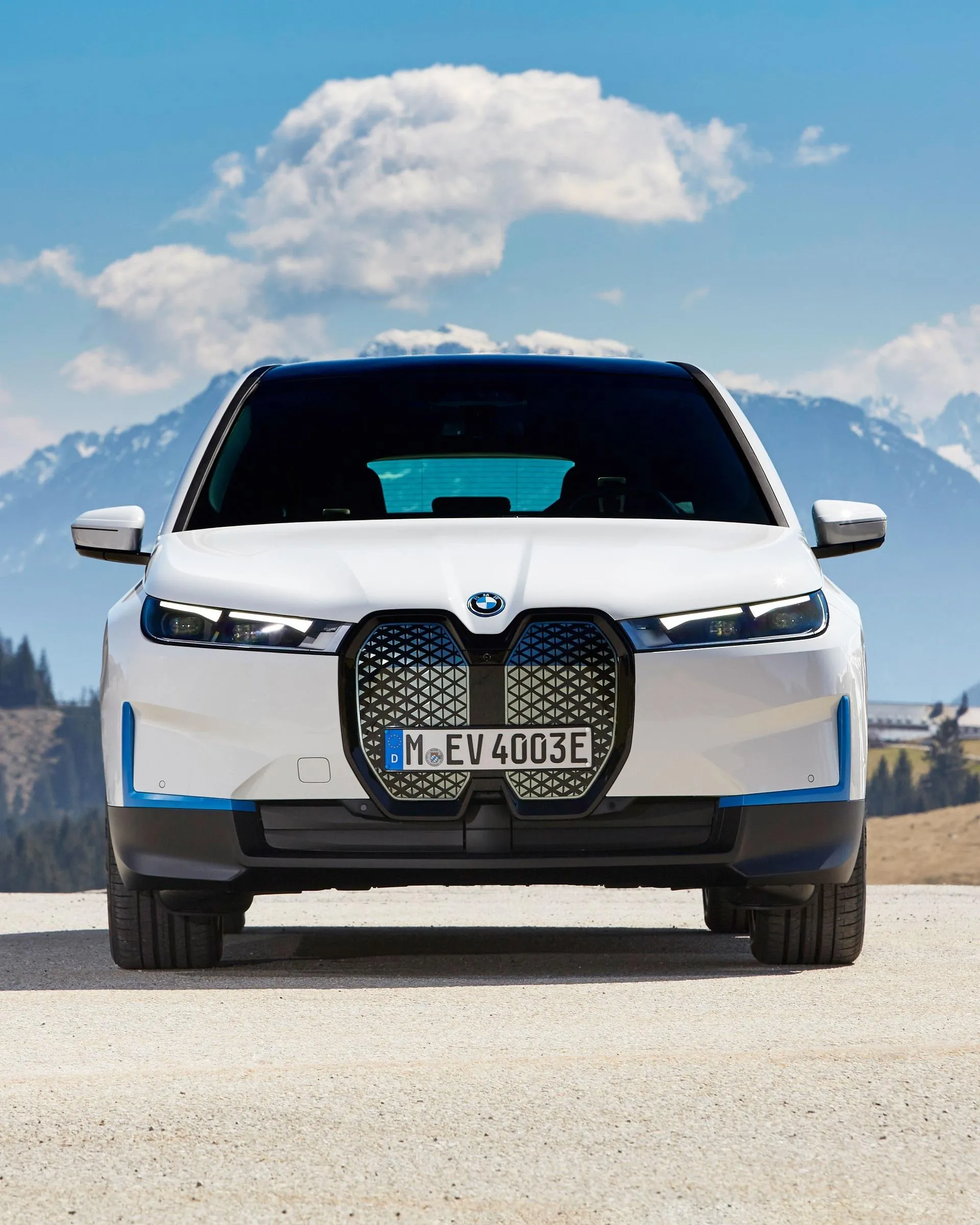 White Electric Bmw Parked in Mountains with Sky and Clouds