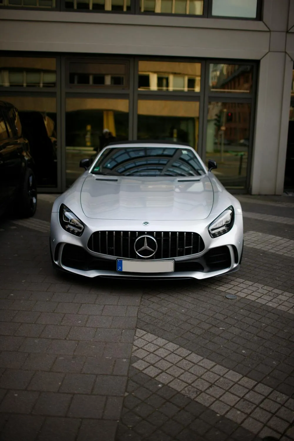 White Mercedes AMG Parked on Paved Entryway at Sunset