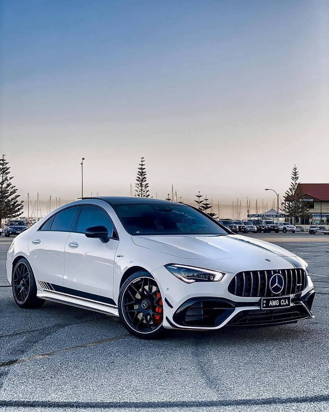 White Mercedes Benz AMG Parked in Open City Lot Wallpaper