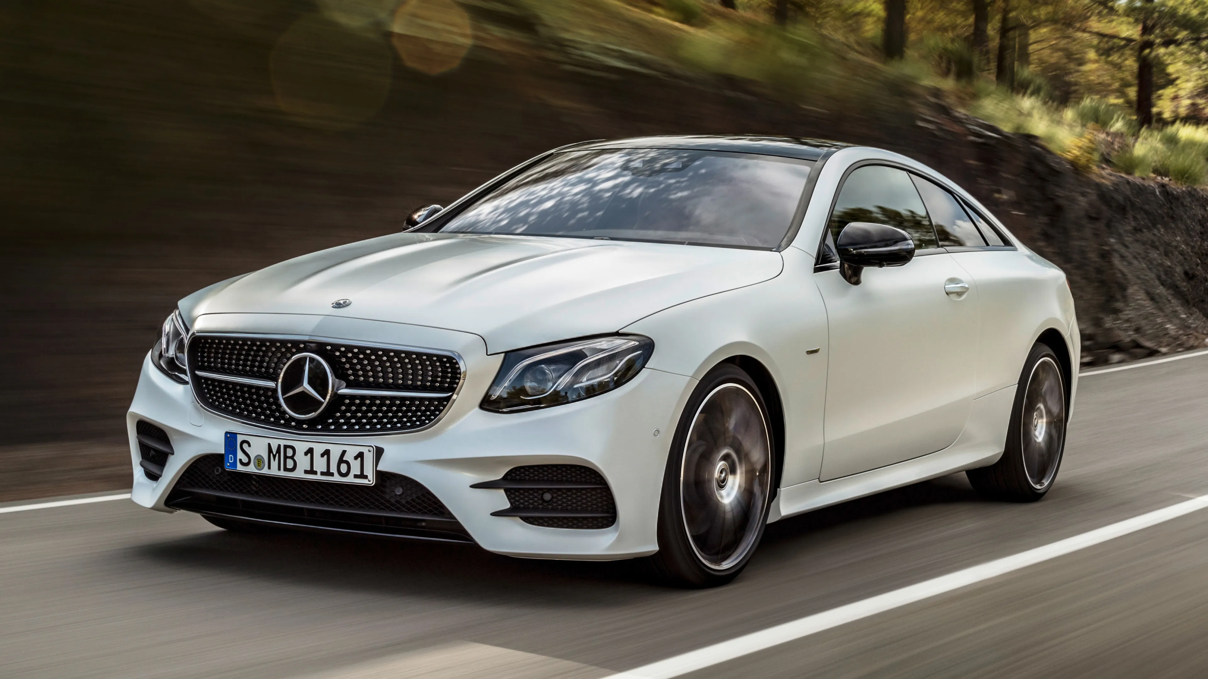 White Mercedes Benz Coupe Driving Fast on Mountain Road