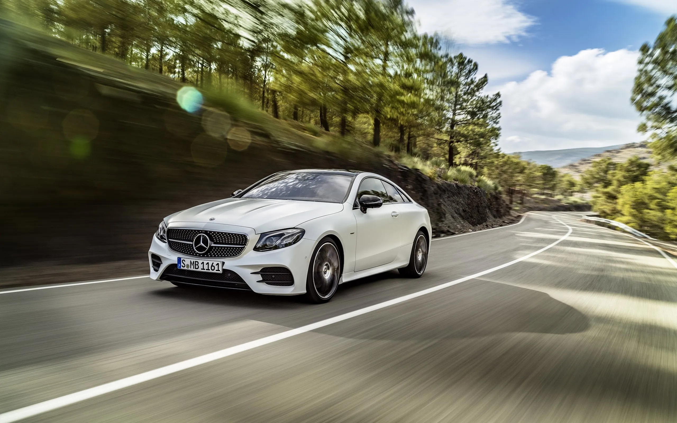 White Mercedes Benz Coupe Driving on Winding Forest Road