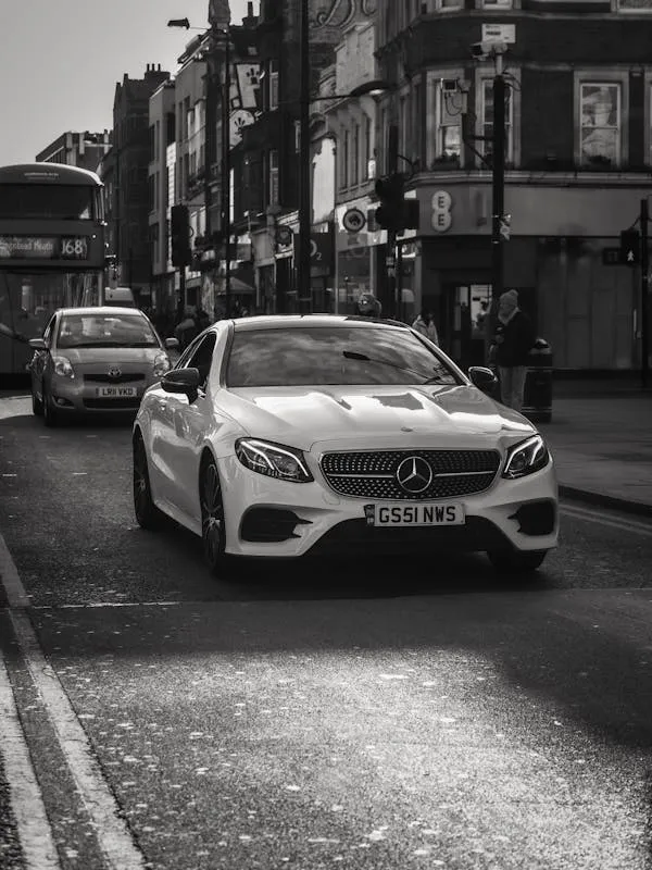 White Mercedes Benz Driving on Busy Urban Road HD image