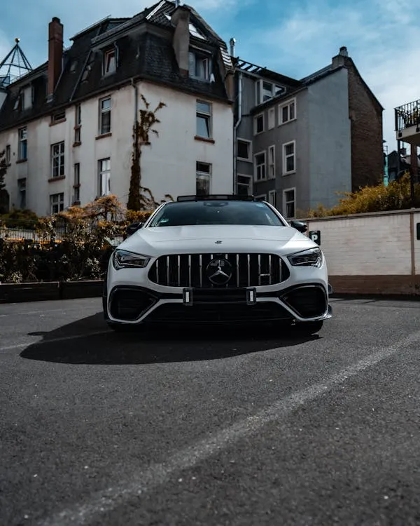 White Mercedes Benz Parked on Urban Street with Buildings