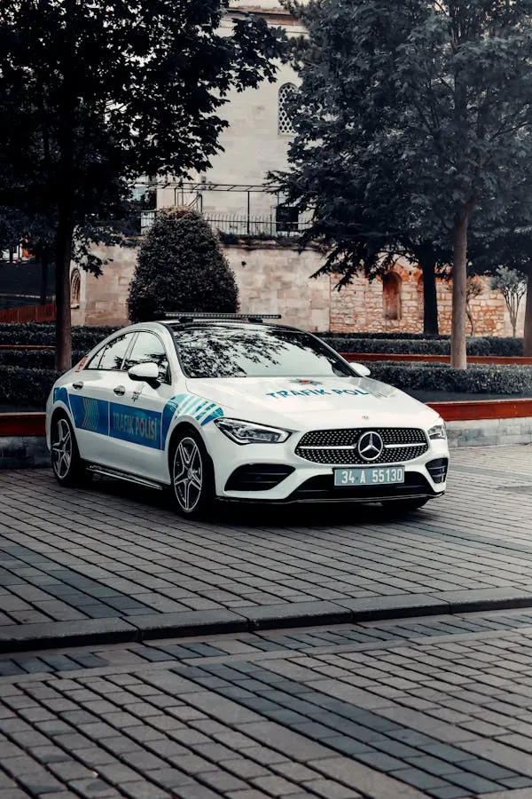 White Mercedes Benz Police Car Parked on City Street