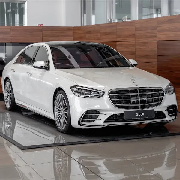 White Mercedes Benz Sedan Displayed in Showroom Wallpaper