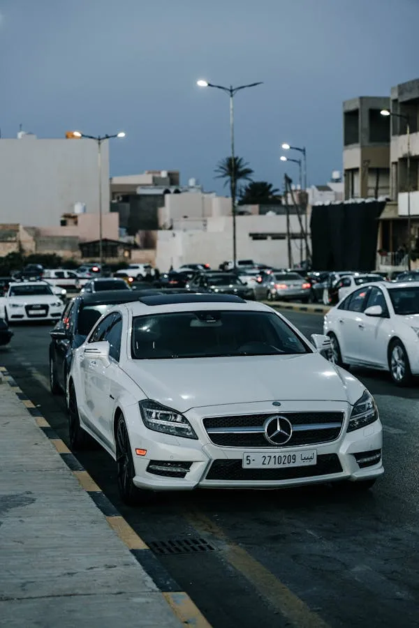 White Mercedes Benz Sedan in Busy Urban Traffic Wallpaper