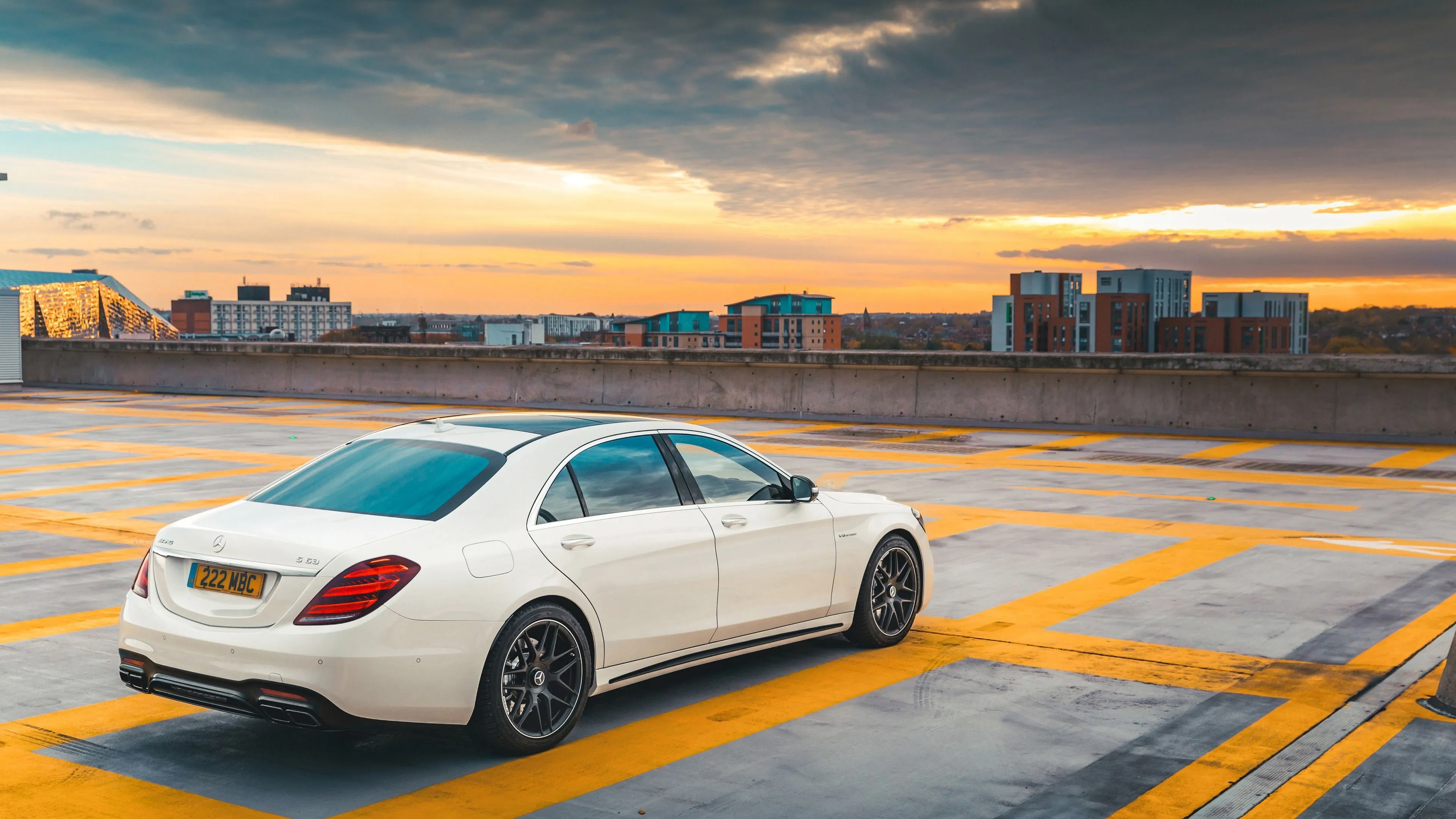 White Mercedes Benz Sedan on Rooftop with City Background