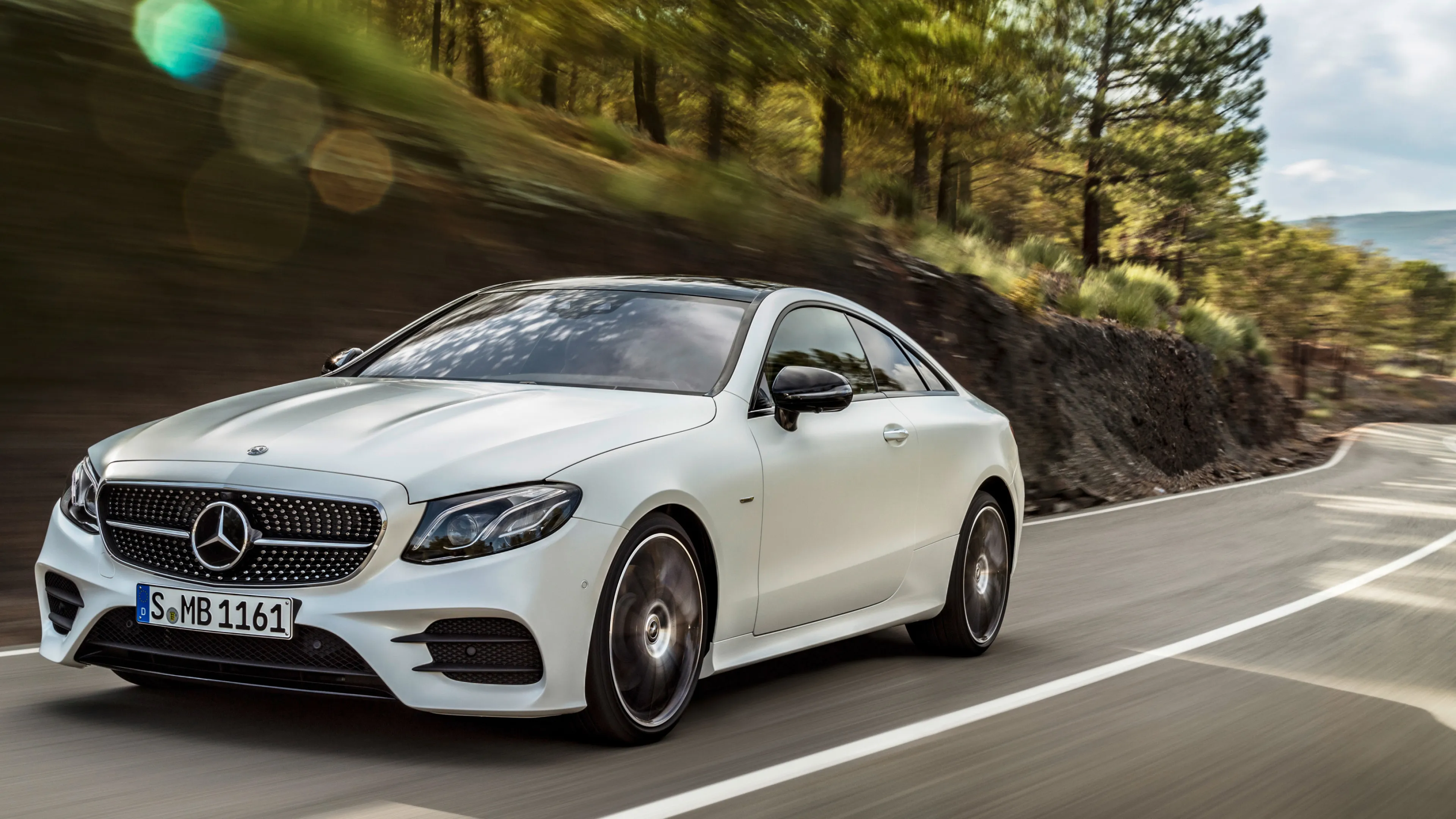 White Mercedes Benz Sports Coupe Driving Through Forest