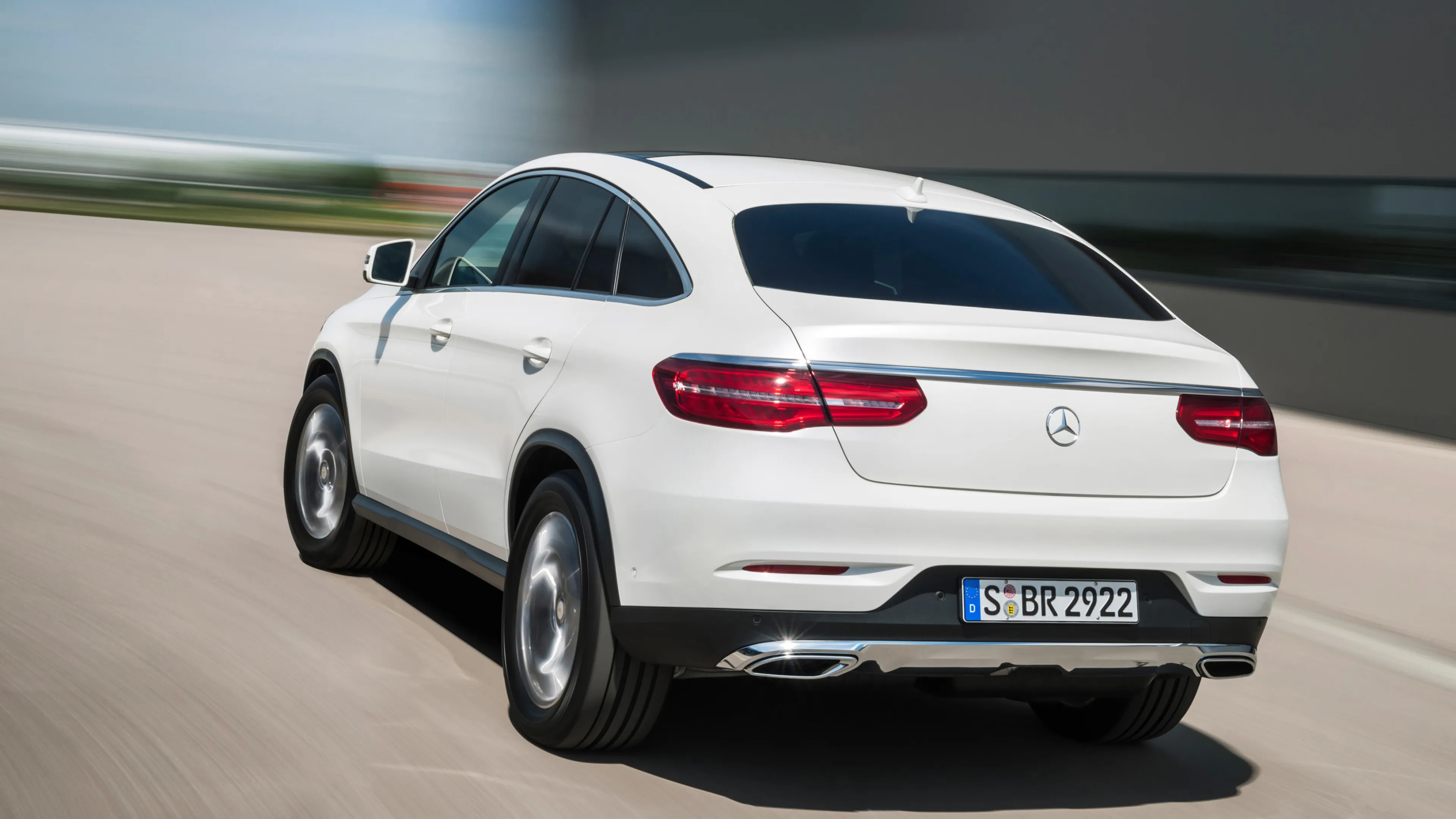 White Mercedes Benz SUV Driving Fast on Open Road Wallpaper