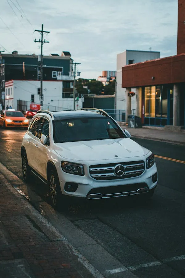 White Mercedes Benz SUV Driving in Urban Area at Dusk
