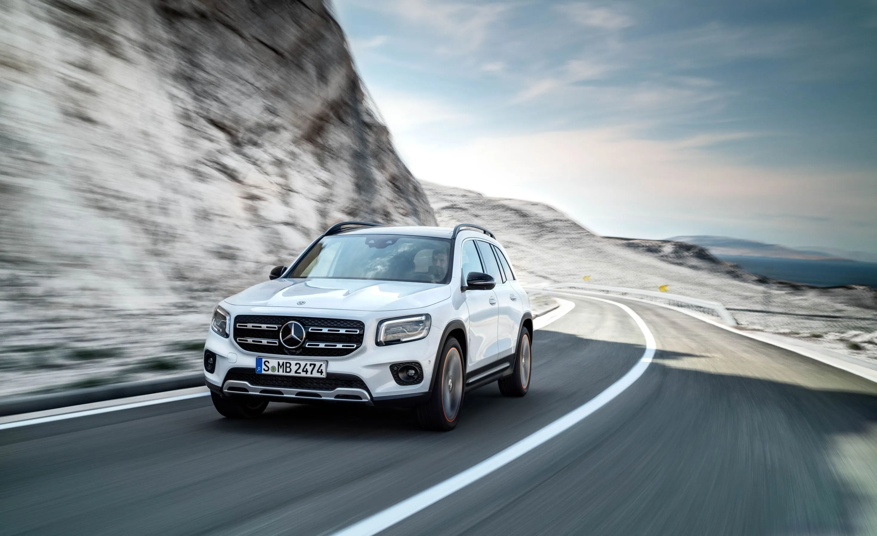 White Mercedes Benz SUV Driving on Mountain Road Wallpaper