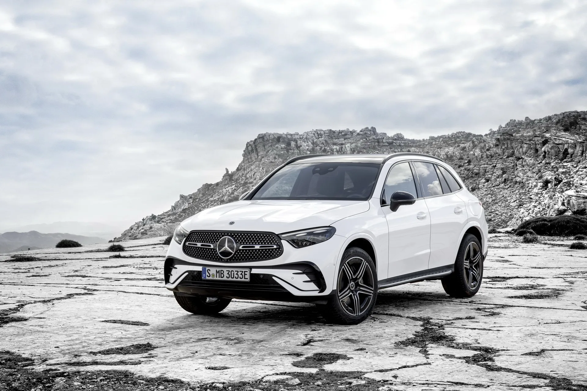 White Mercedes Benz SUV on Rocky Mountain Landscape