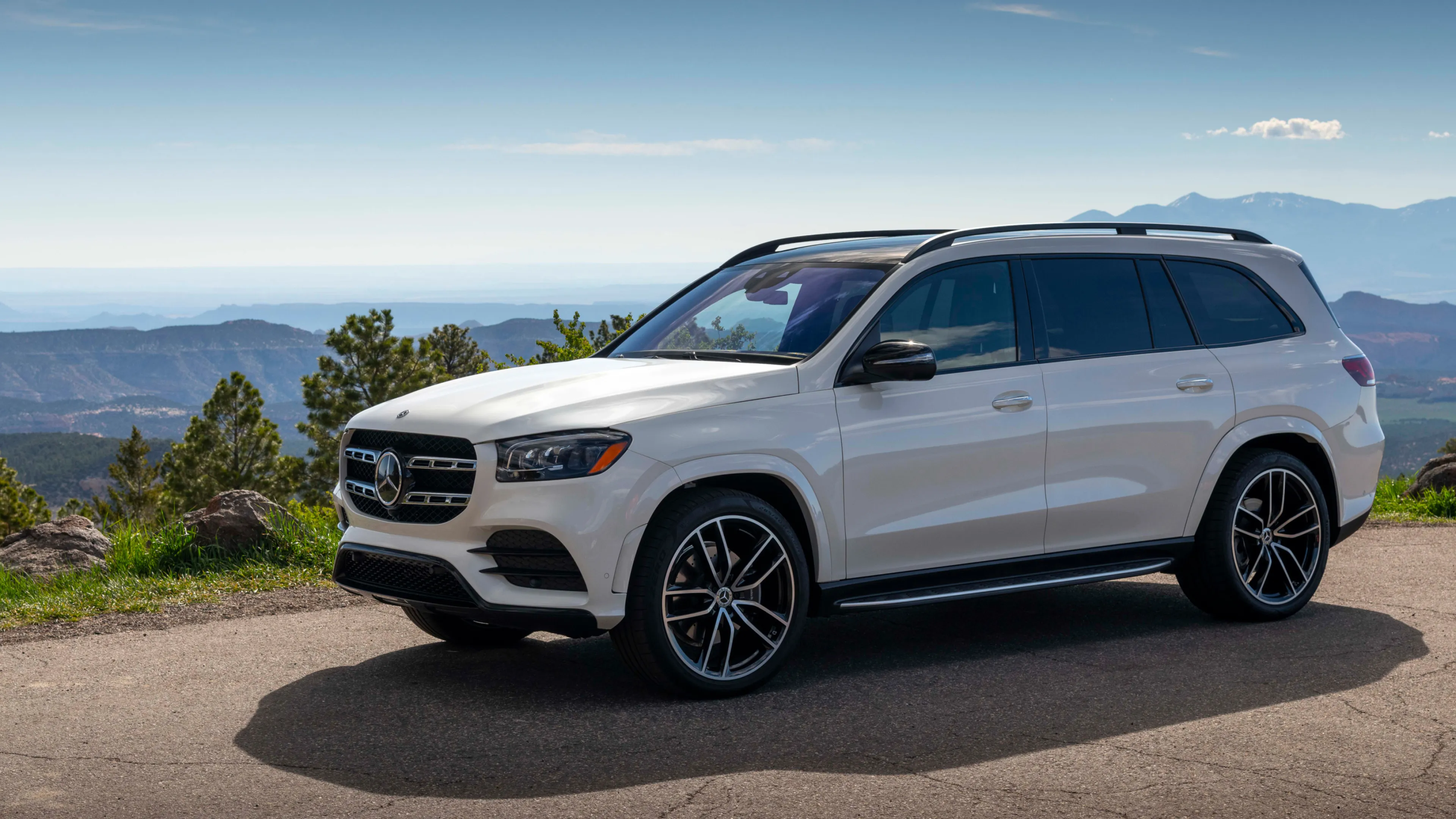White Mercedes Benz SUV Parked with Mountain Background