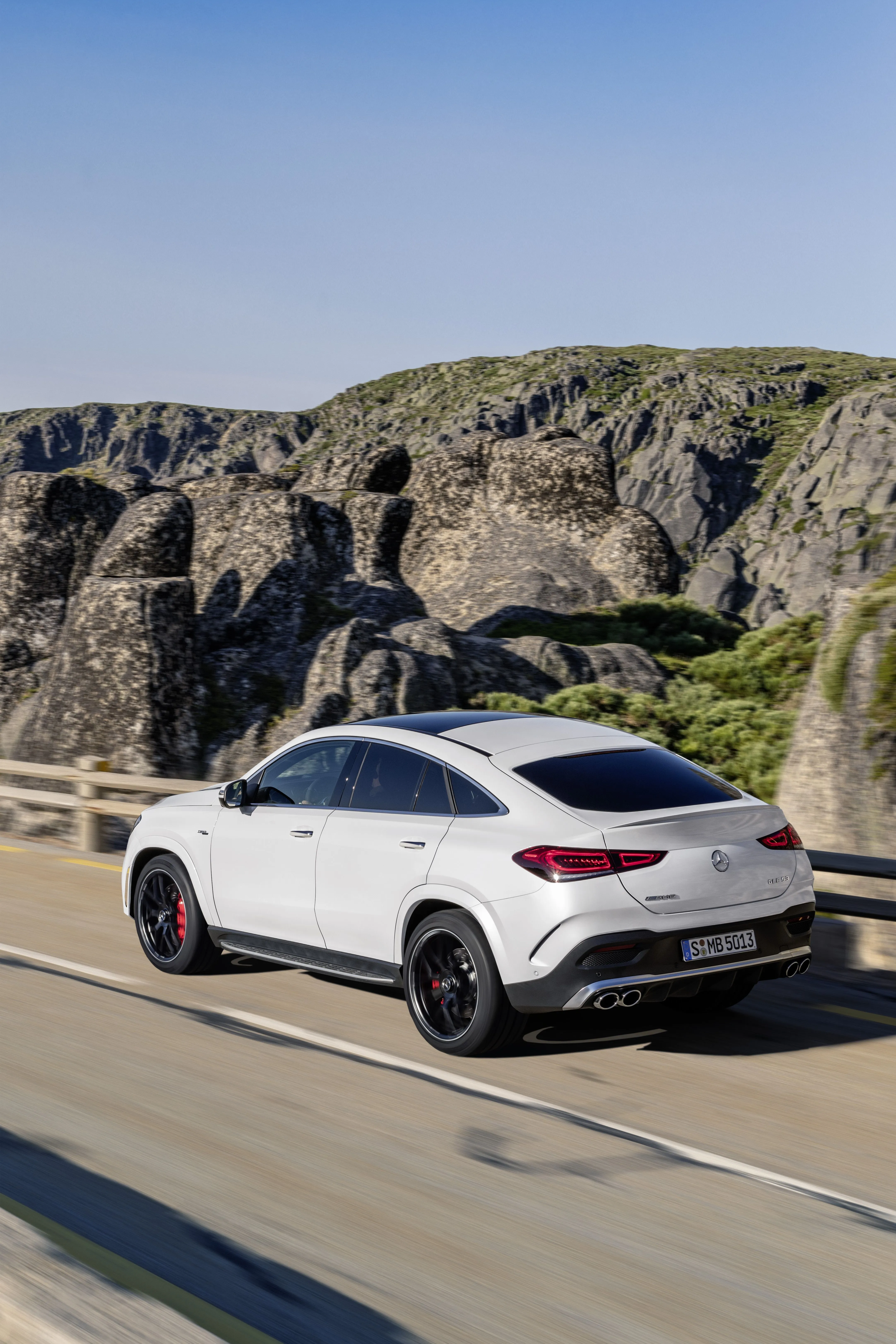 White Mercedes Crossover Driving Through Mountain Pass
