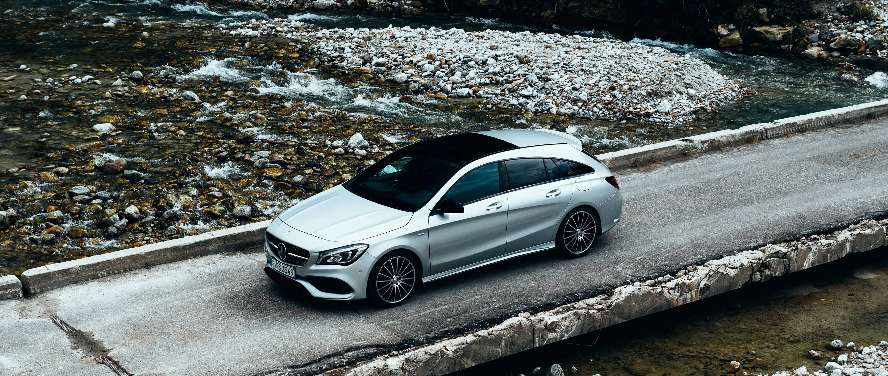 White Mercedes Driving on a Stone Covered lake Road image