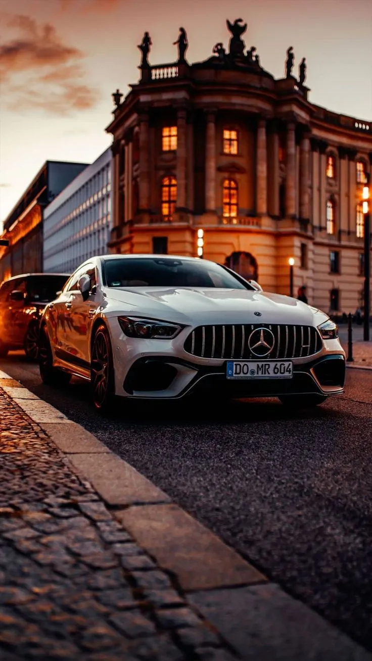 White Mercedes Parked by Historic Building at Sunset