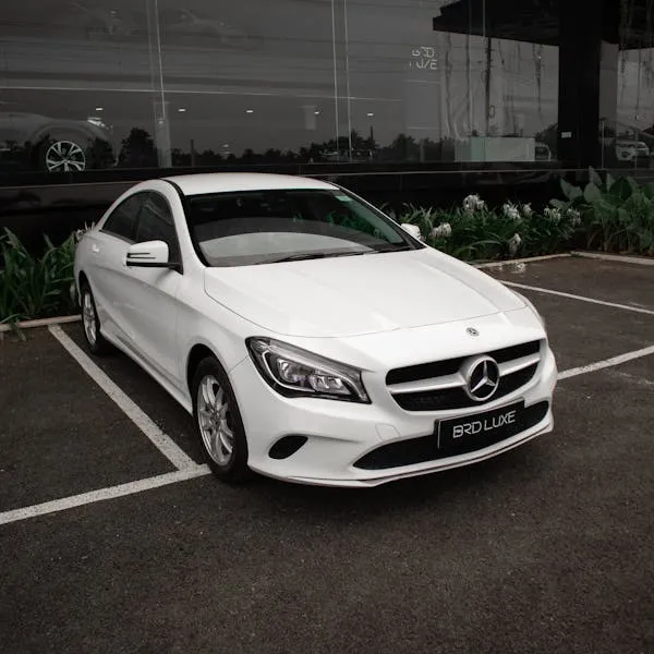 White Mercedes Sedan Parked in Front of Glass Building