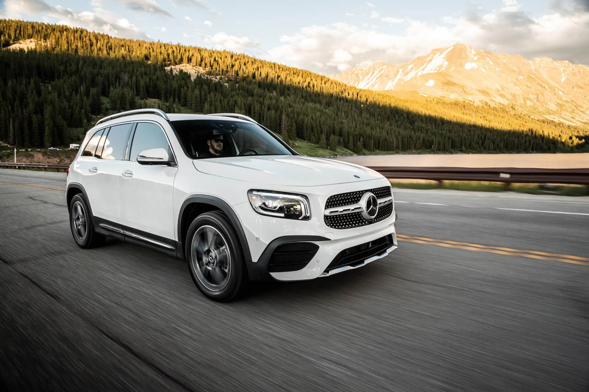 White Mercedes SUV Driving in Scenic Mountain Landscape