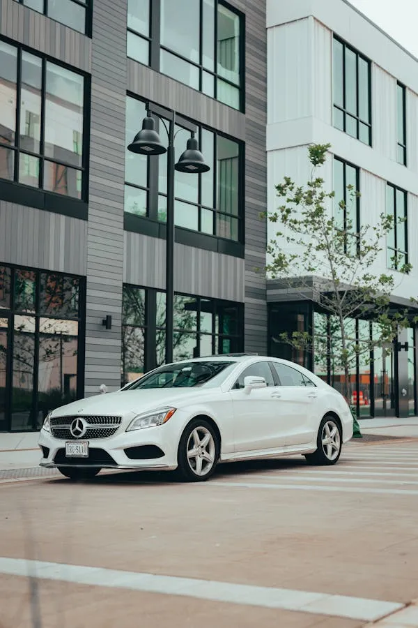 White modern Mercedes parked near office buildings Wallpaper