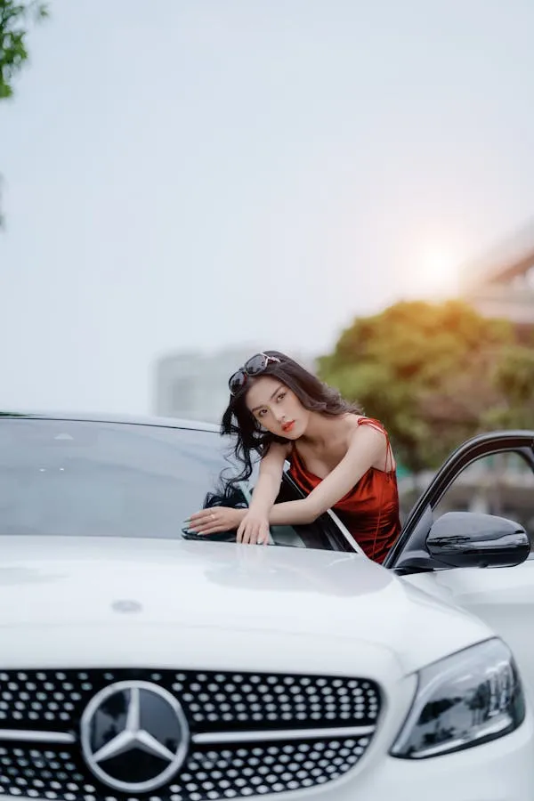 Woman in red Posing on White Mercedes Benz Car Hood image