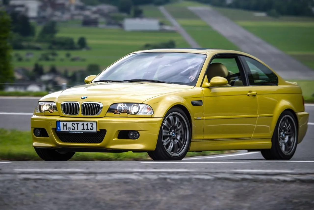 Yellow Bmw Driving on a Road in a Rural Green Area