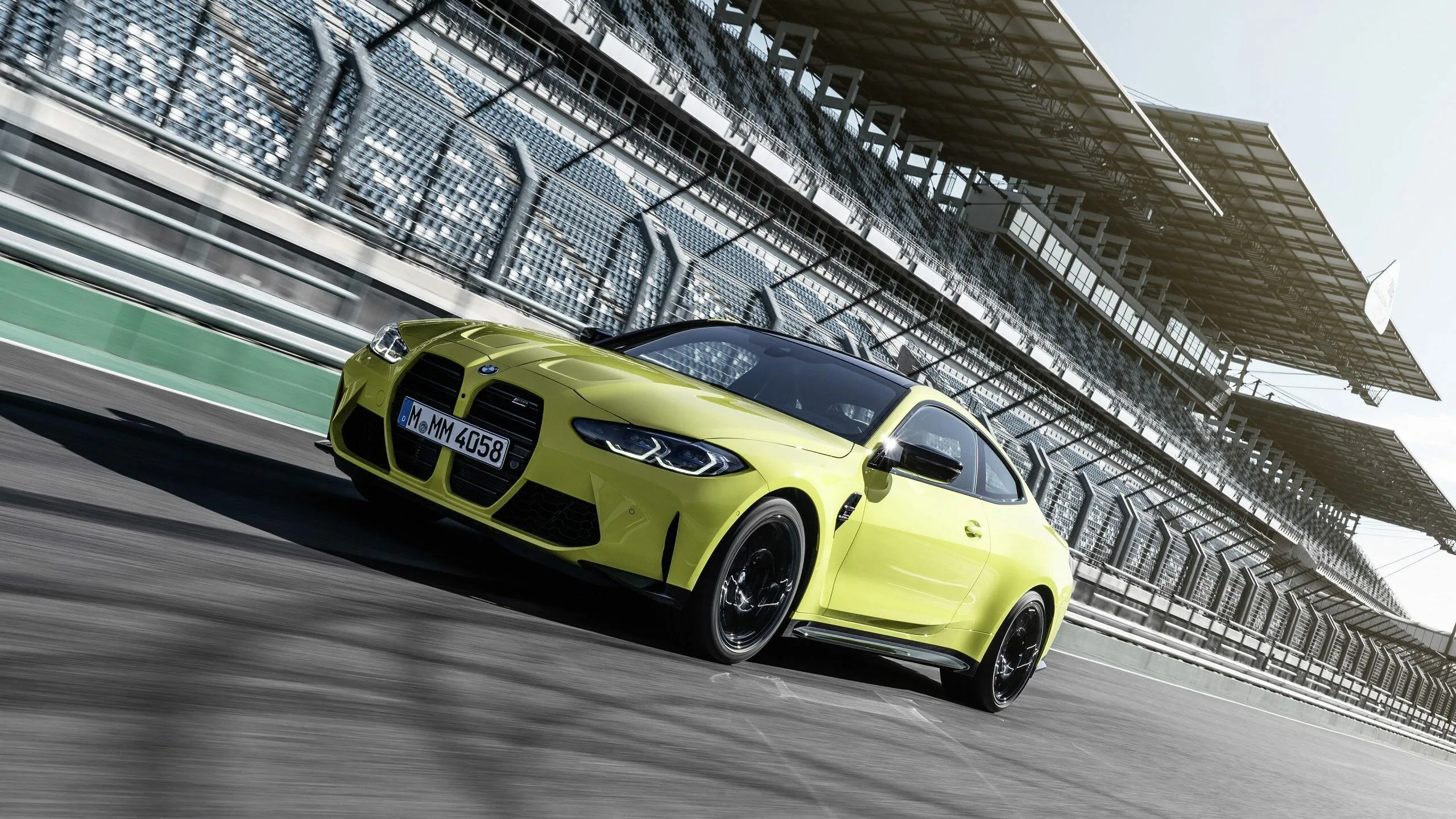 Yellow Bmw Sports Car Racing on a Track in Motion Wallpaper
