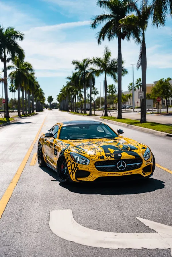 Yellow Mercedes AMG Driving on Palm Tree Lined Road image