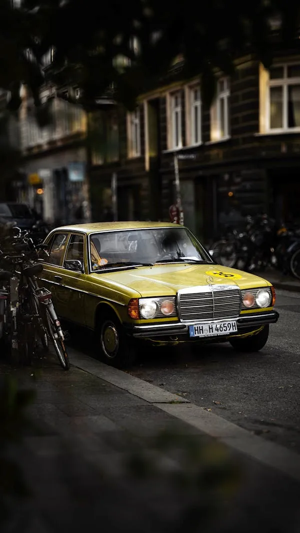 Yellow Mercedes Benz Car Driving on Rainy City Street
