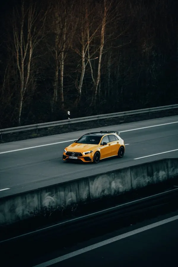 Yellow Mercedes Benz Driving on Forest Highway Wallpaper