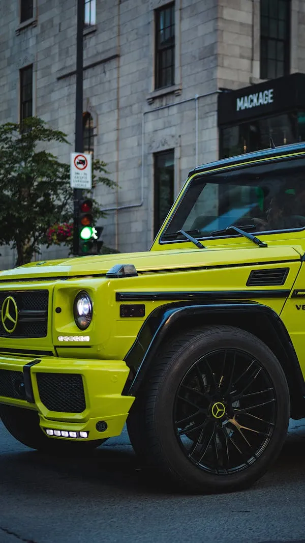 Yellow Mercedes G Wagon Parked Near City Store Wallpaper